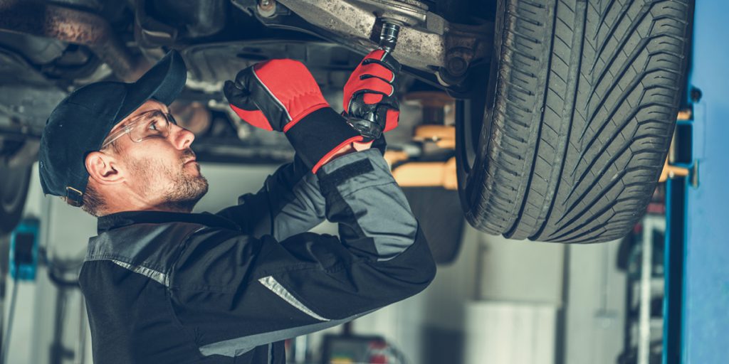 Mecânico avaliando suspensão do carro, onde está o coxim do amortecedor.